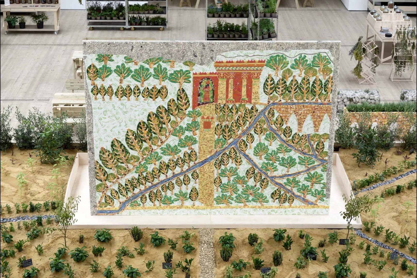 The colors on the panel are those that archaeologists believe were used on the original stone panel. The architectural footprint of the North Palace of Nineveh is recreated in the layout of the garden beds, shelves, and workstations behind the panel,