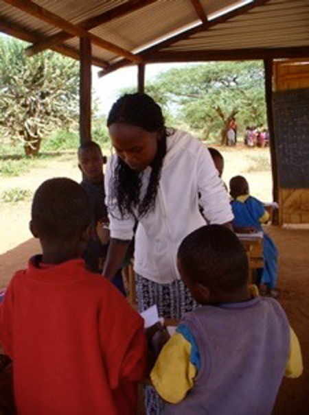  In the Isiolo district, teaching Intern Eunice instructs some young students in basic arithmetic. 