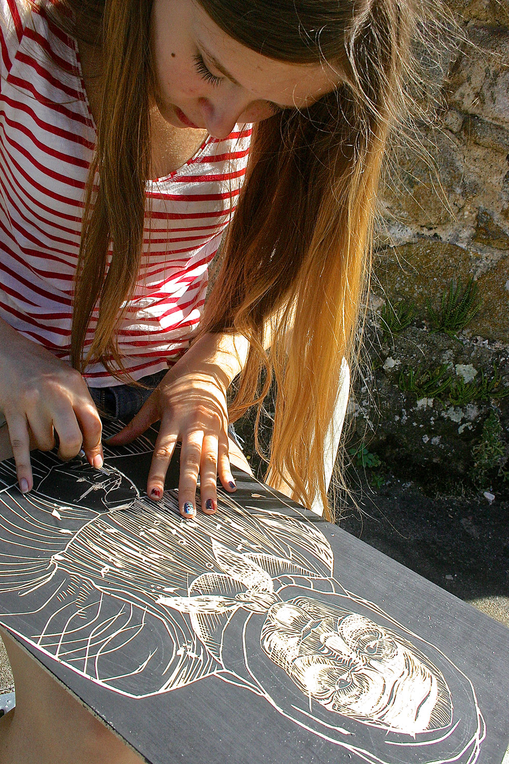  high school student working on a woodcut print at les tapies art programs 