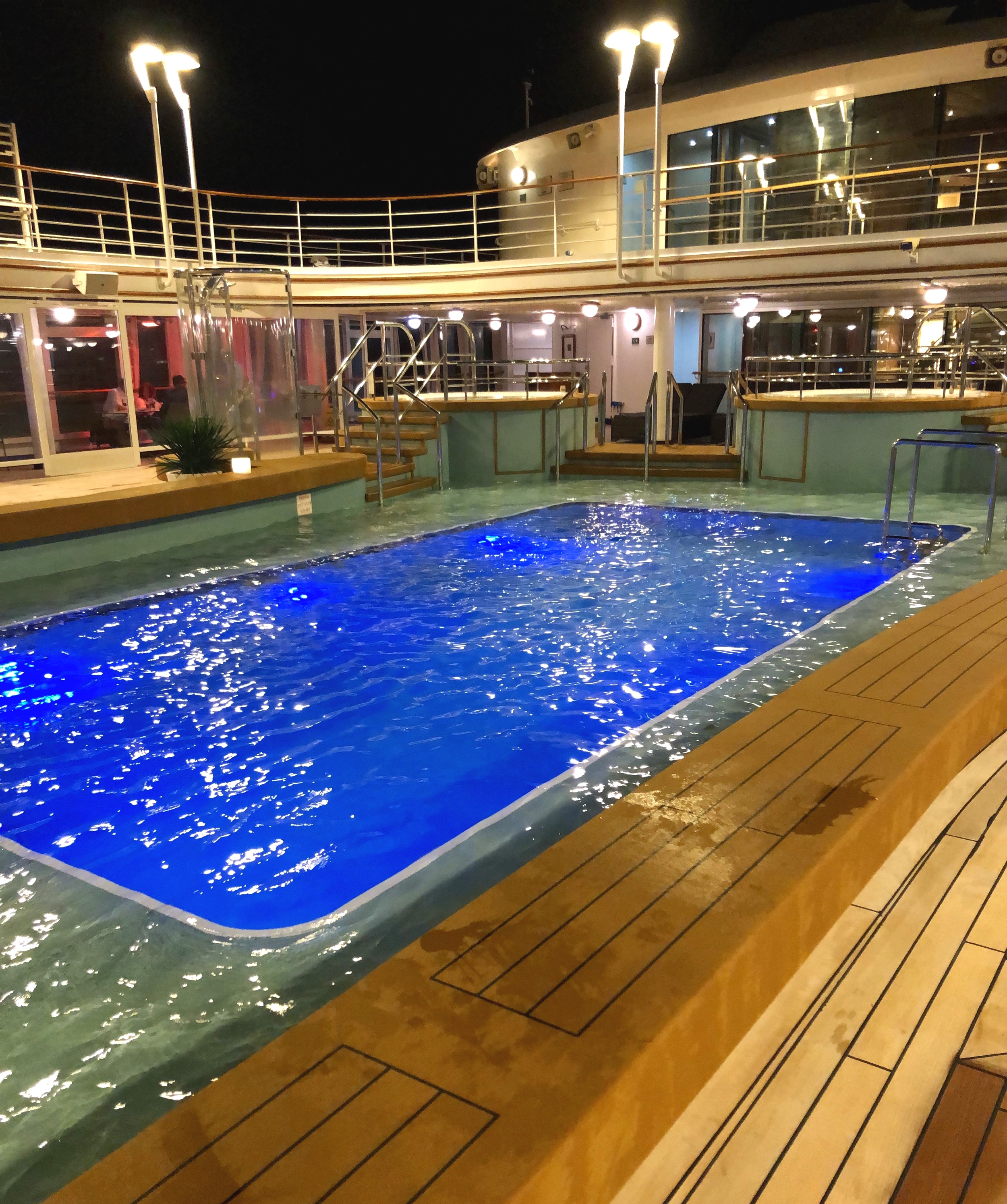 The beautifully lit pool deck at night.