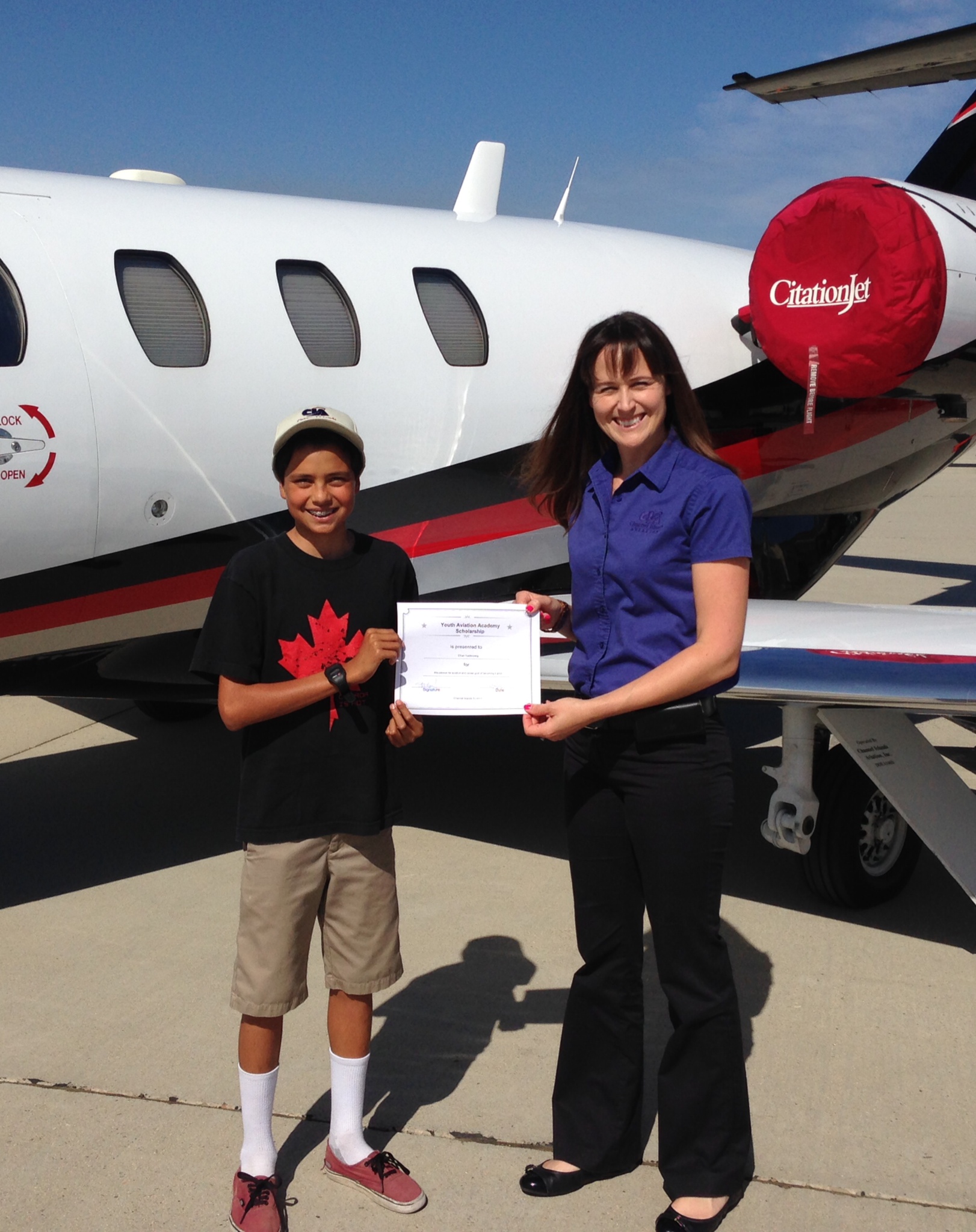 Ethan Kastenberg, 12, receives scholarship from Sarah Oberman Bartush, flight school manager.