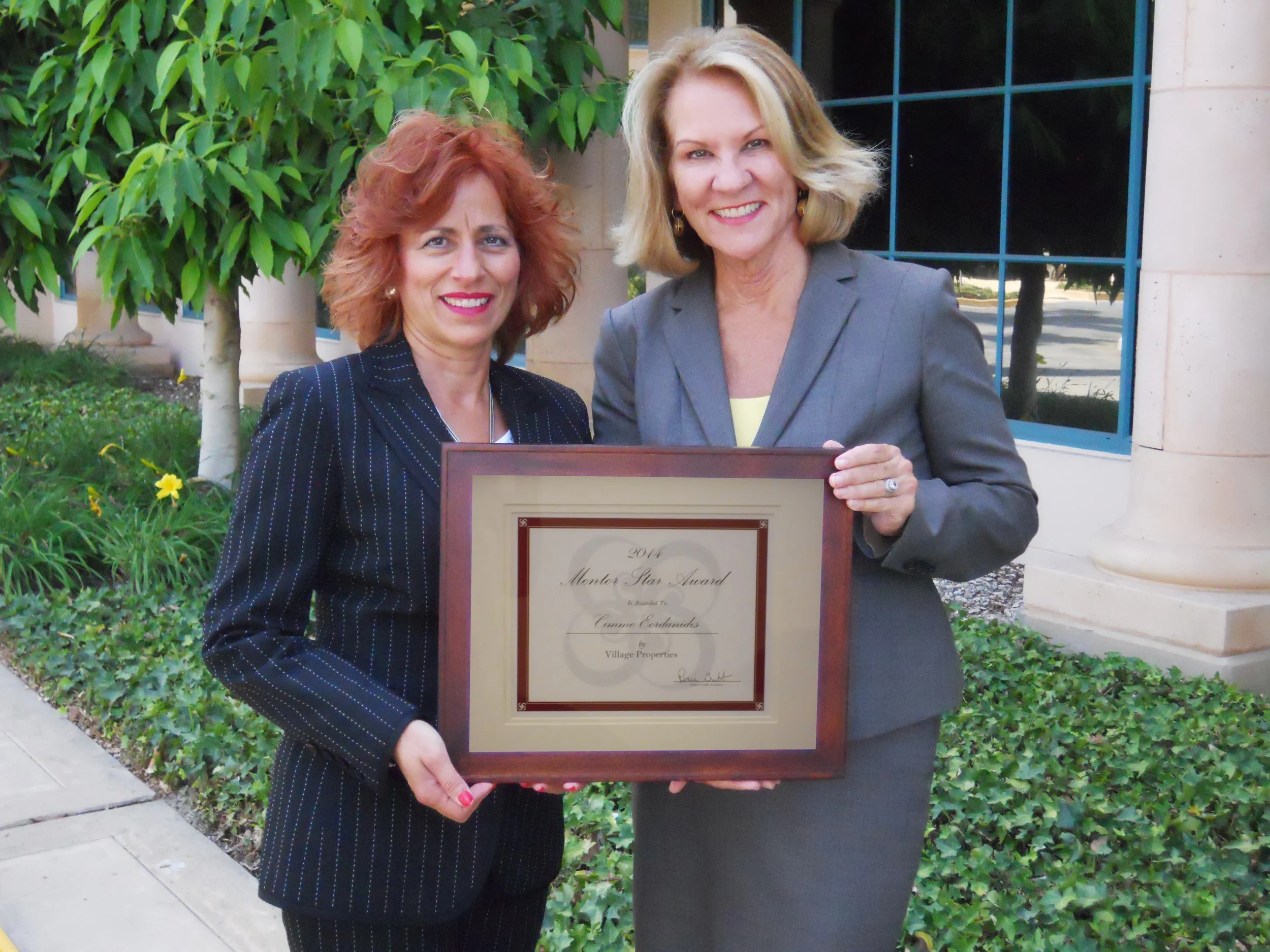 Renee Grubb (right), of Village Properties, hands Cimme Eordanidis her Star Mentee award.