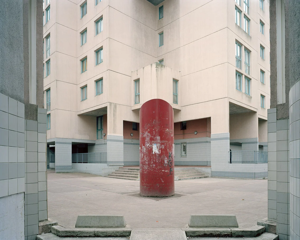 Banlieues #5 – Cité des Beaudottes, Sevran, Seine-Saint-Denis, 2006. 40"x50" l'habitat marginalisé artist's statement An enclosed courtyard like this one illustrates perfectly the failures of its modernist design. After the construction of public housing projects all over the world in the ‘60s it was quickly noticed that though there were large areas of open space, this space was usually enclosed and cut off from any sort of vehicle throughway or heavy foot traffic. What were designed to be open public spaces have ended up becoming havens for all sorts of crime. With little or no traffic moving through these places, they become hidden enclaves that protect drug dealing and other nefarious activities from the eyes of police patrols. 