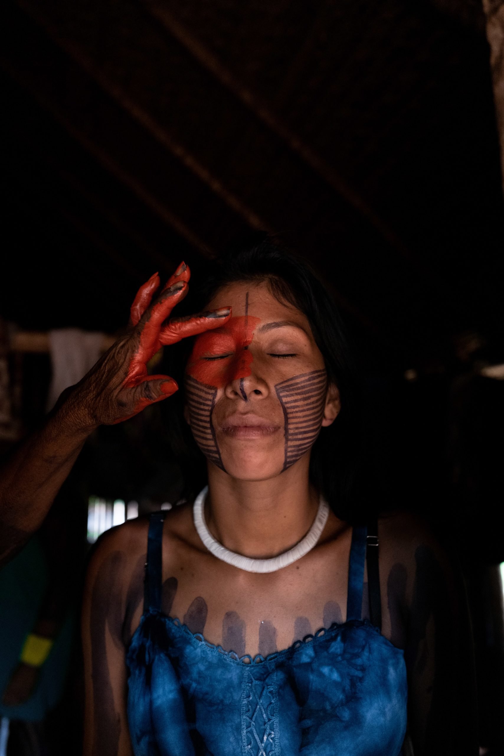  Irepoti får sitt ansikte målat med Achiote av en äldre i samhället. Foto: Alice Aedy     