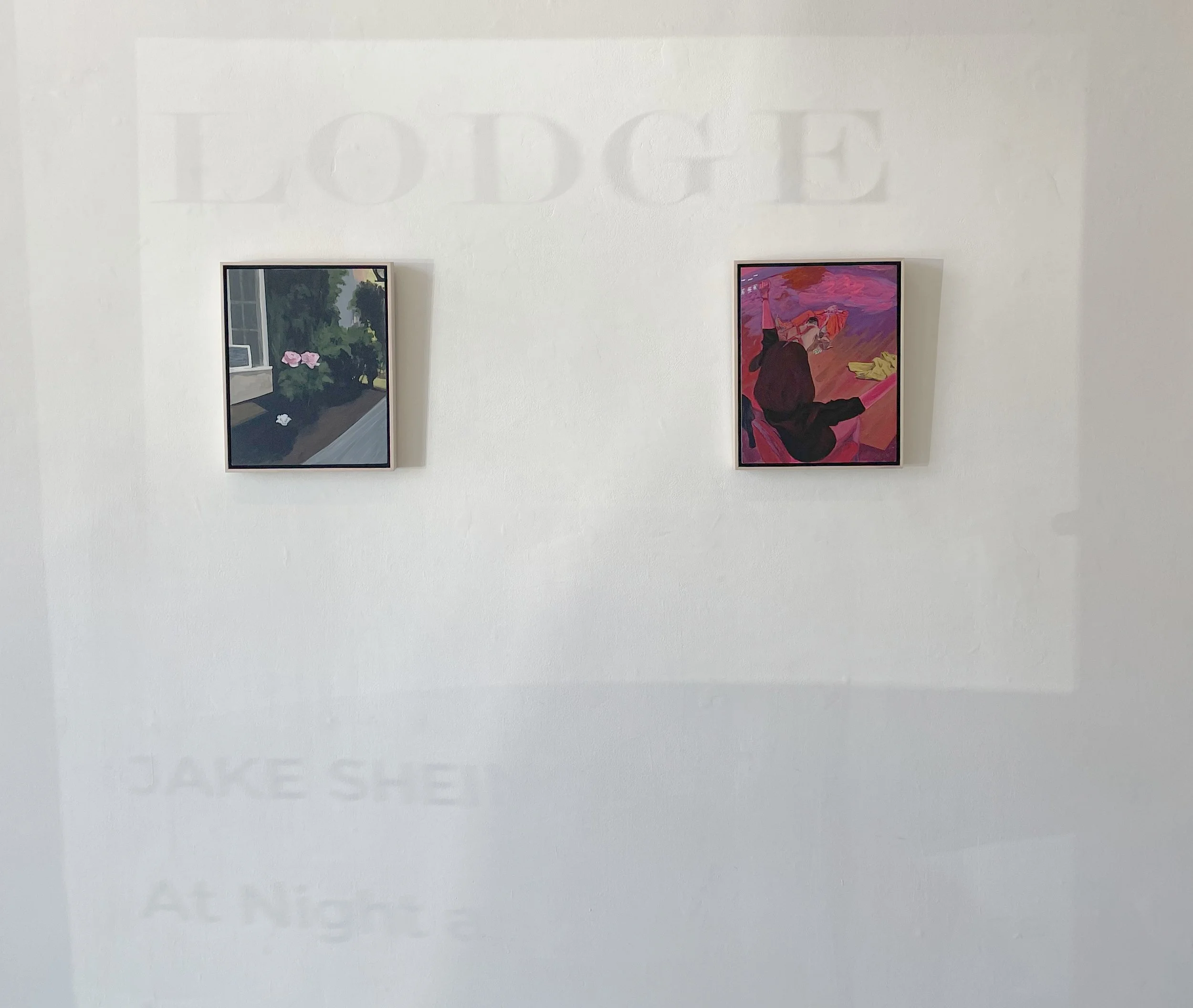 Two framed artworks hanging on a white gallery wall.