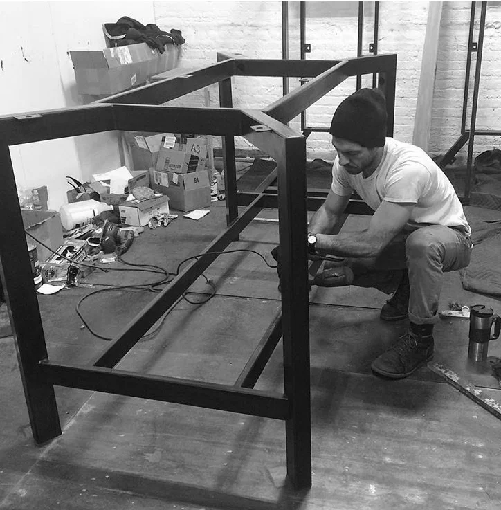Jason Hernandez working on a blackened steel table base.