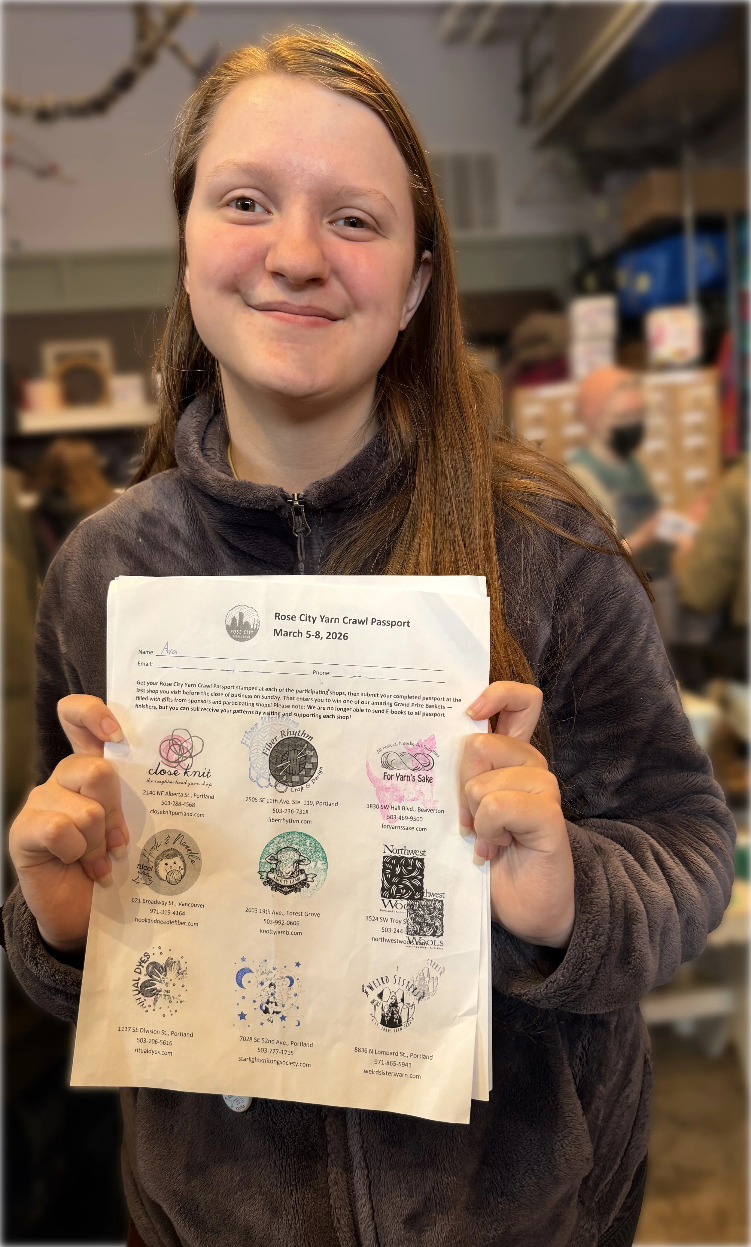 Girl holding a sheet of paper covered in stamps.