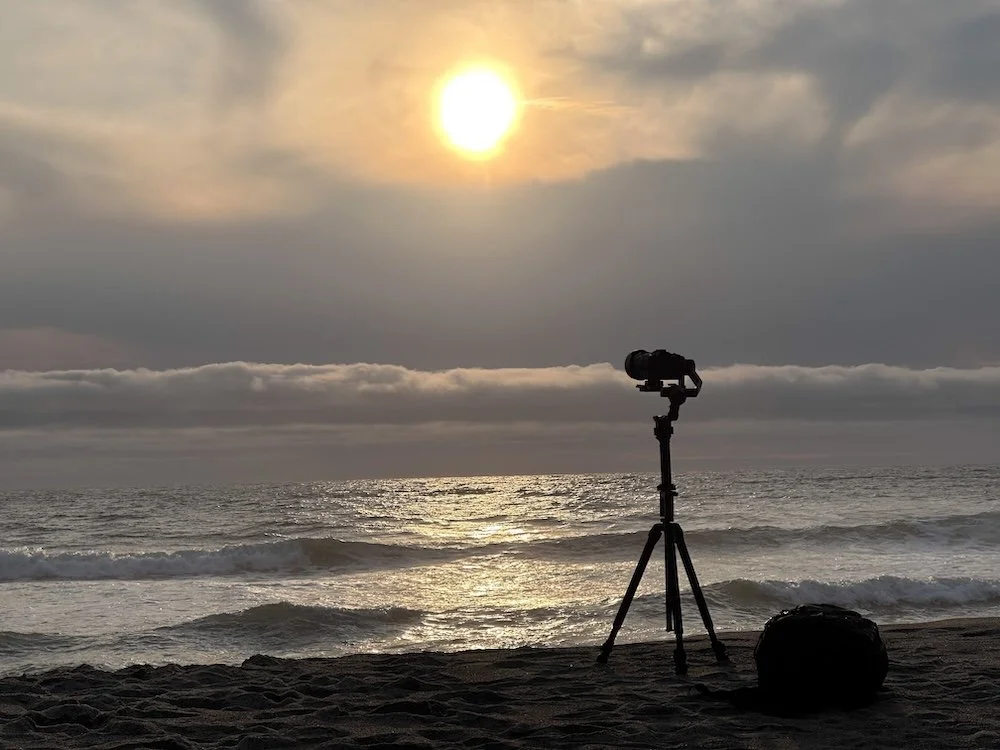 A camera taking a time lape of a sunset on the Oregon Coast.