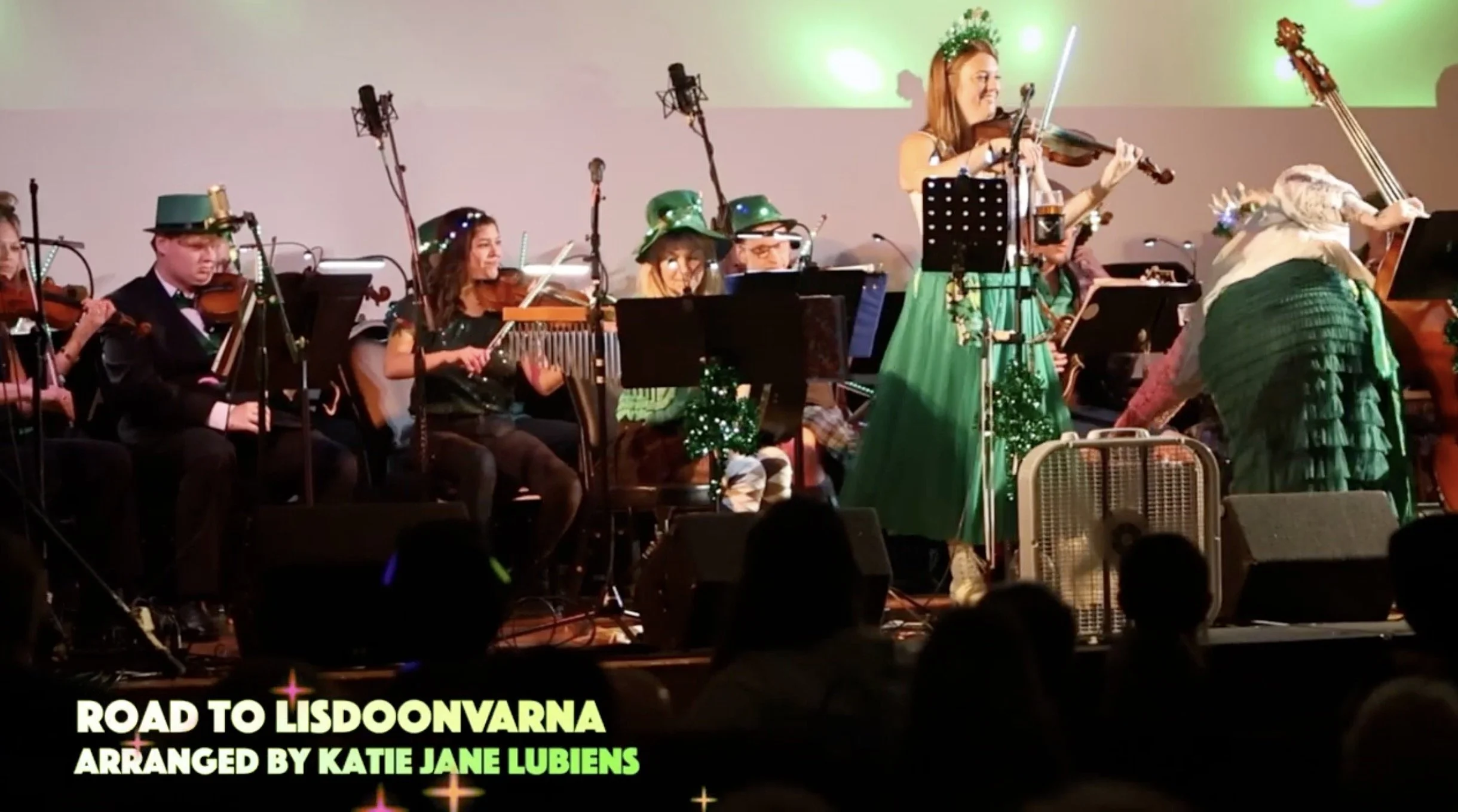 Still from a musical performance. There is a graphic in the lower right corner with the words "Road to Lisdoonvarna, Arranged by Katie Jane Lubins", with good visual contrast to ensure legibility.