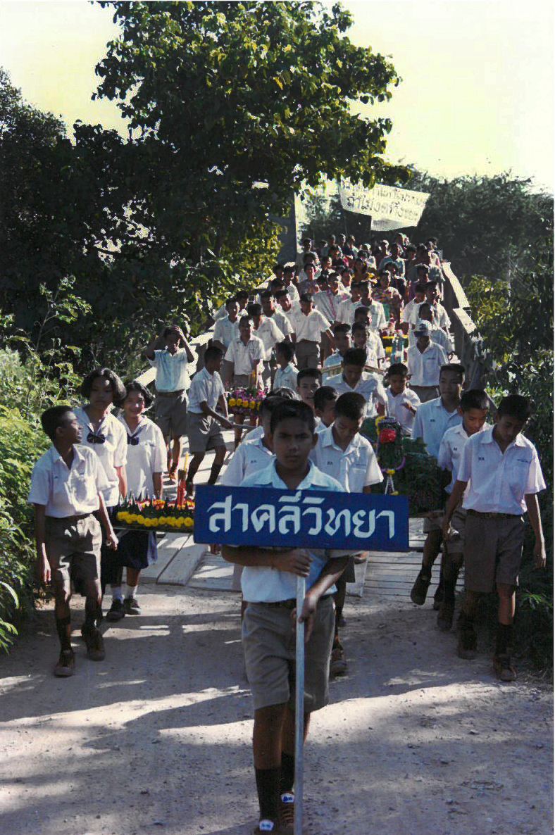 My students walking over the bridge in our village during a ceremony. The sign says Sa Klee Wittaya, the name of their school.
