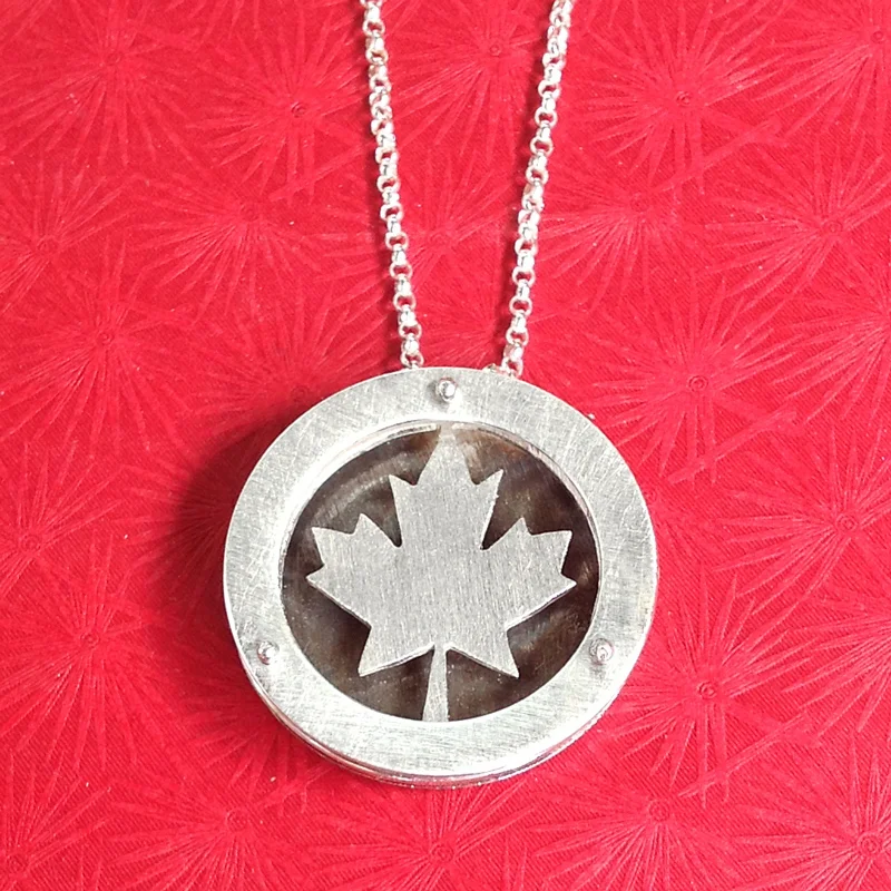 Large circle shadowbox necklace with Canadian maple leaf.