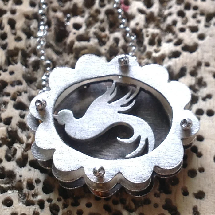 Small scalloped shadowbox necklace with swallow.