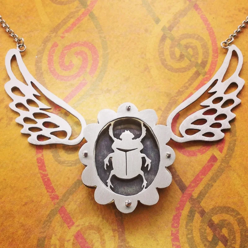 Large scalloped shadowbox necklace with scarab and sterling wings.