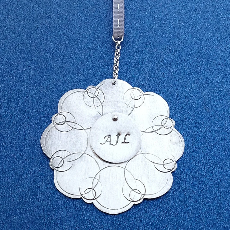 Nickle ornament with stacked sterling disc and stamped initials.
