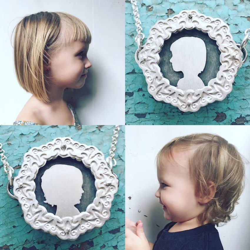 Five layer, two sided small etched shadowbox necklace featuring silhouettes of children.