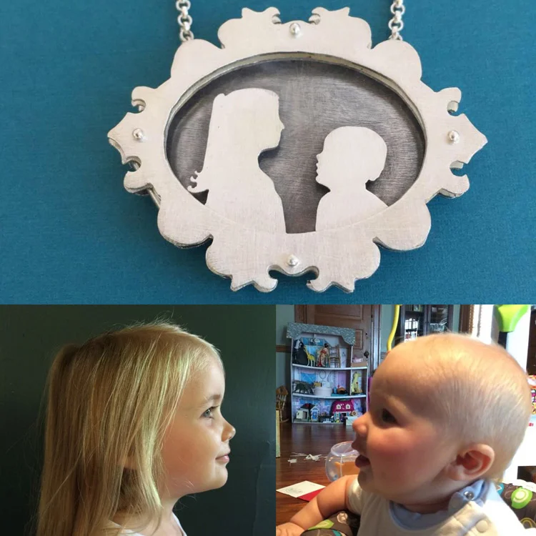Ornate shadowbox necklace with silhouettes of children.