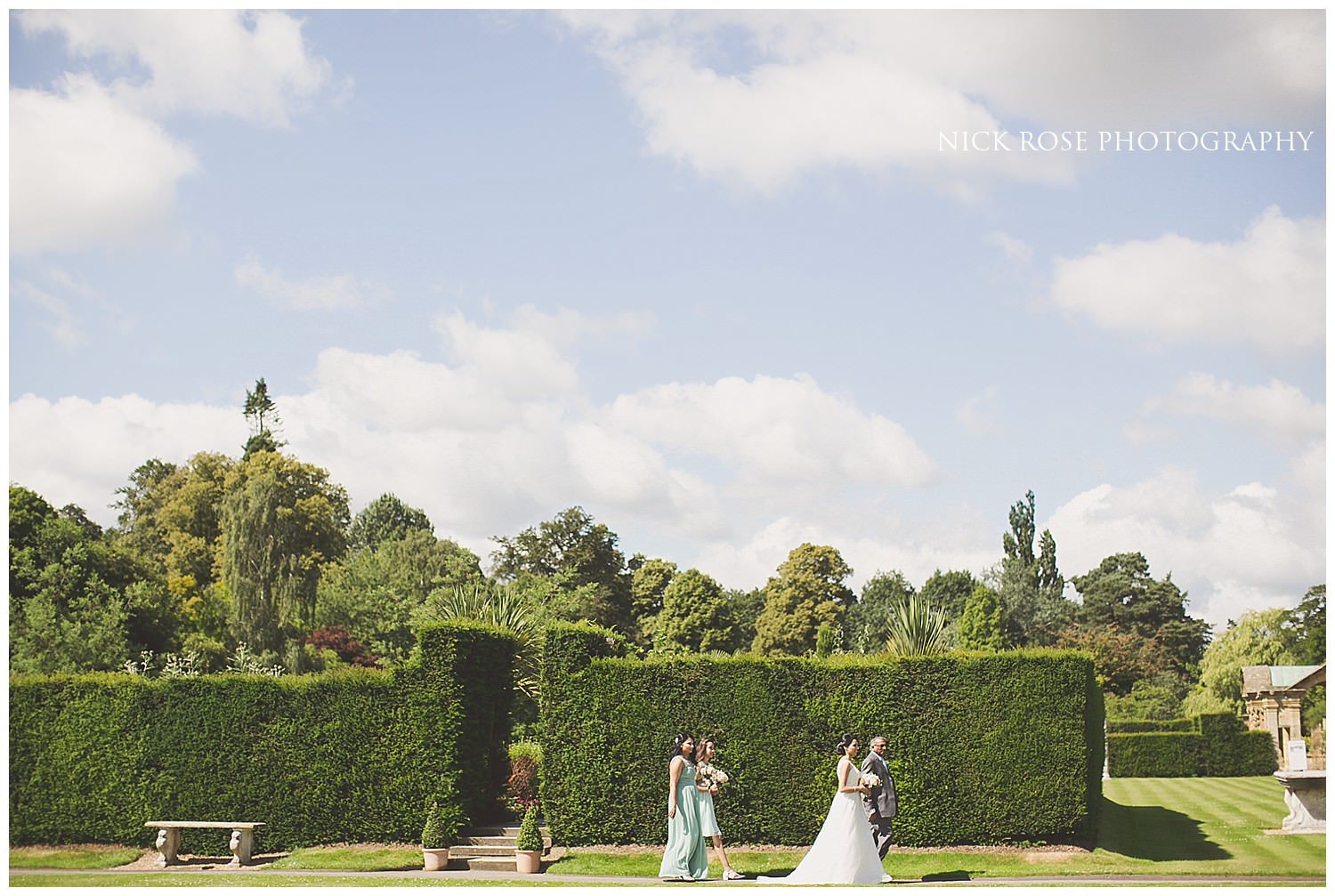  Bride walking across the gardens before a Hever Castle wedding ceremony in Kent 