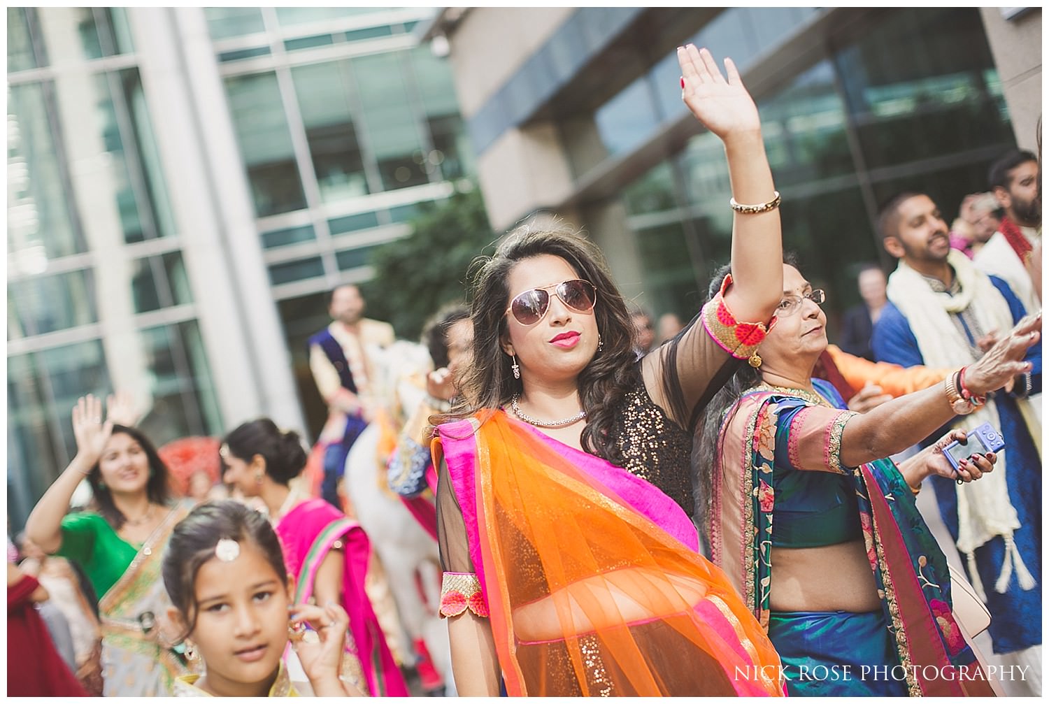  Indian wedding guests dancing during the groom's Baraat Hindu wedding entrance in London 