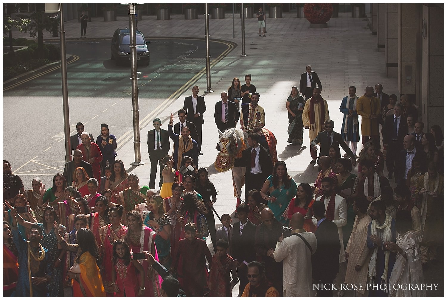  Colourful hindu Baraat wedding entrance with the Indian groom on a horse in Canary Wharf 