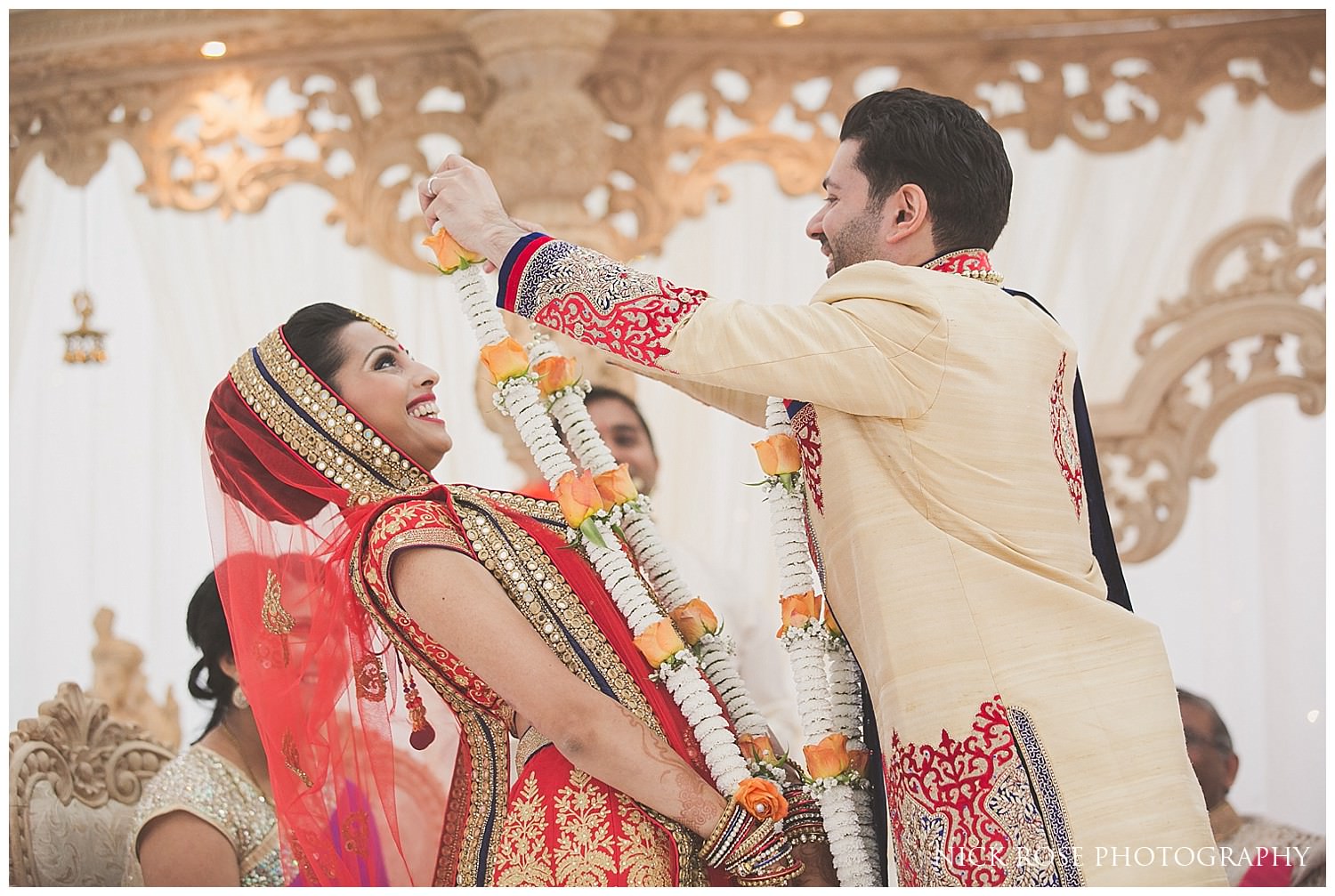  Bride and groom exchanging garlands during an Indian East Wintergarden Hindu wedding in Canary Wharf London 