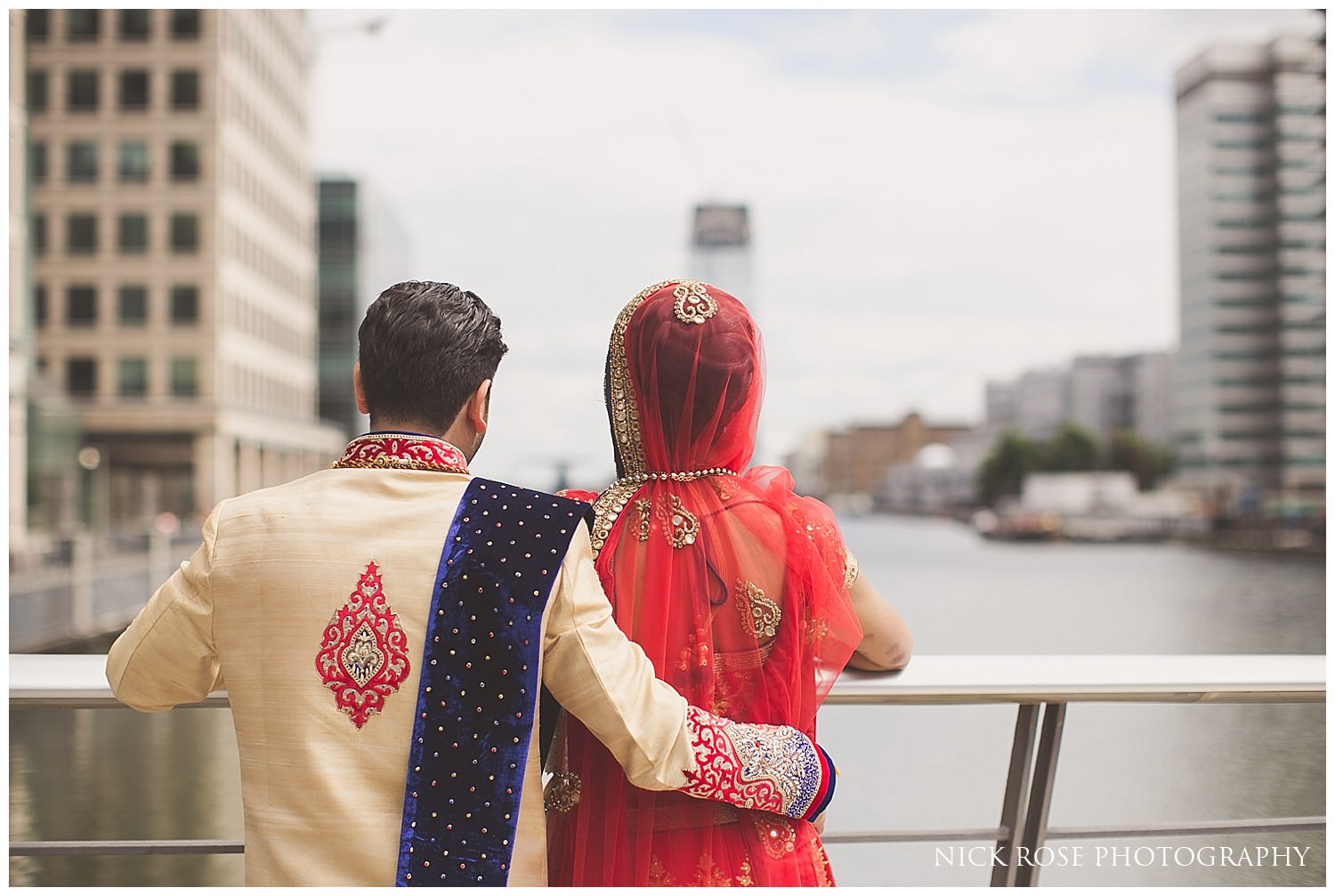  Indian bride and groom looking over the water at Canary Wharf in London 