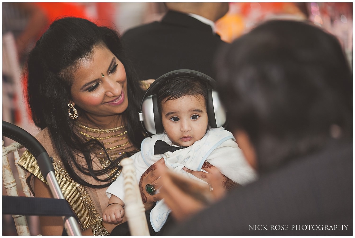  Baby with ear defenders for an Asian wedding in London 