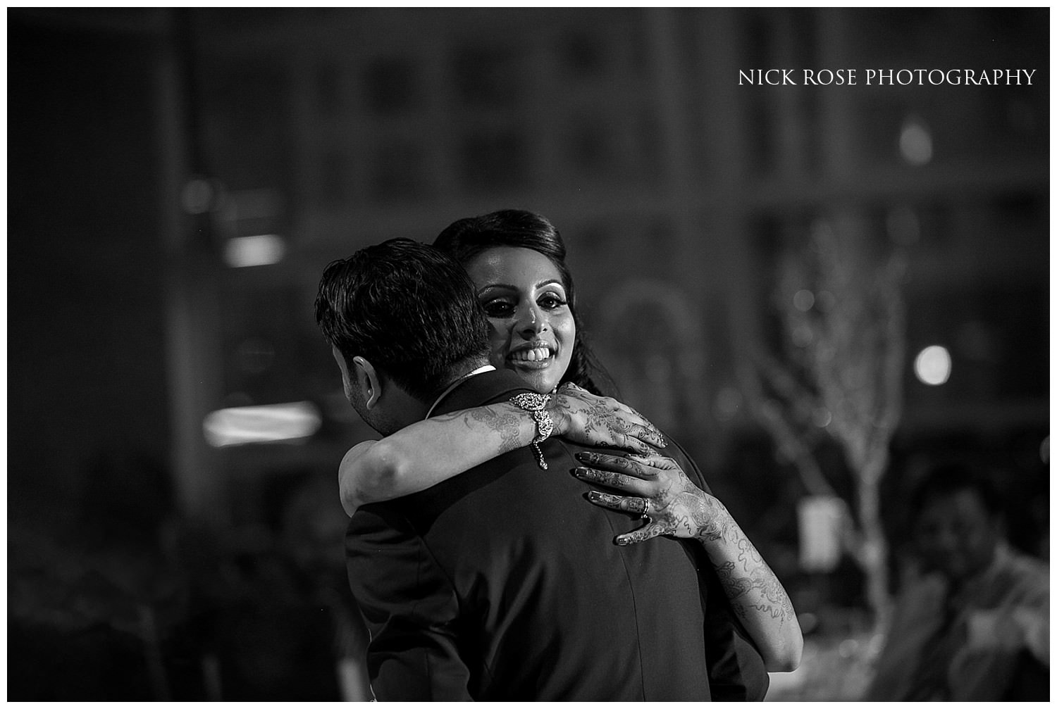  Bride and groom hug on the dance floor at a Hindu wedding reception in East Wintergarden Canary Wharf London 