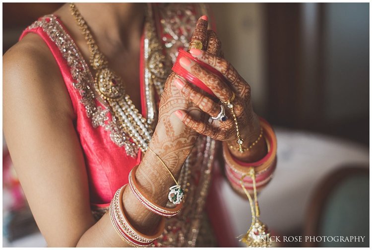  Indian bride putting on bracelet and bangles for a Hindu wedding at the Sofitel Palm Dubai 