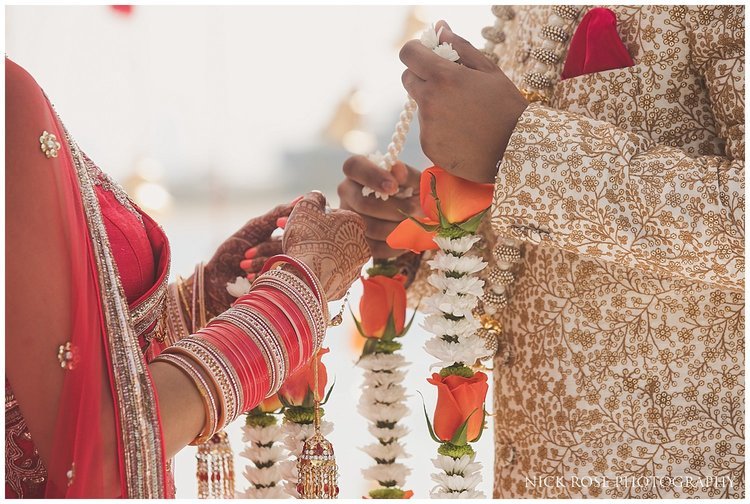  Indian bride and groom exchanging garlands during a destination Hindu wedding ceremony in Dubai 