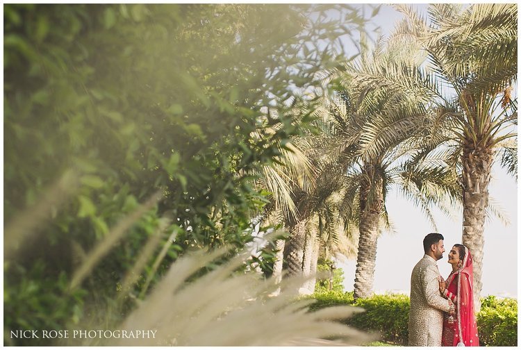 Bride and groom under palm trees in Dubai for a destination Hindu wedding at the Sofitel Palm Dubai