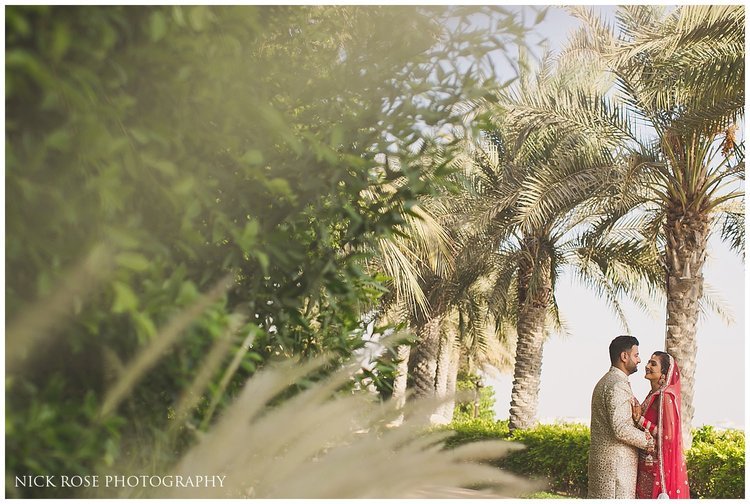  Bride and groom under palm trees in Dubai for a destination Hindu wedding at the Sofitel Palm Dubai 