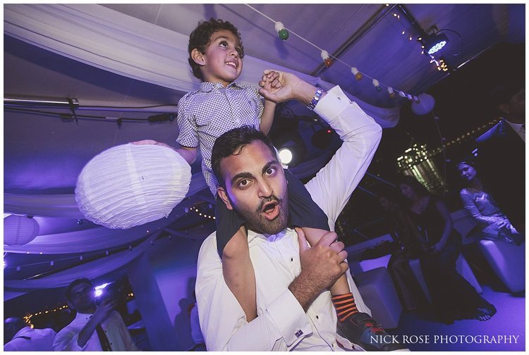  Boy dancing on a mans shoulders during a destination Dubai wedding 