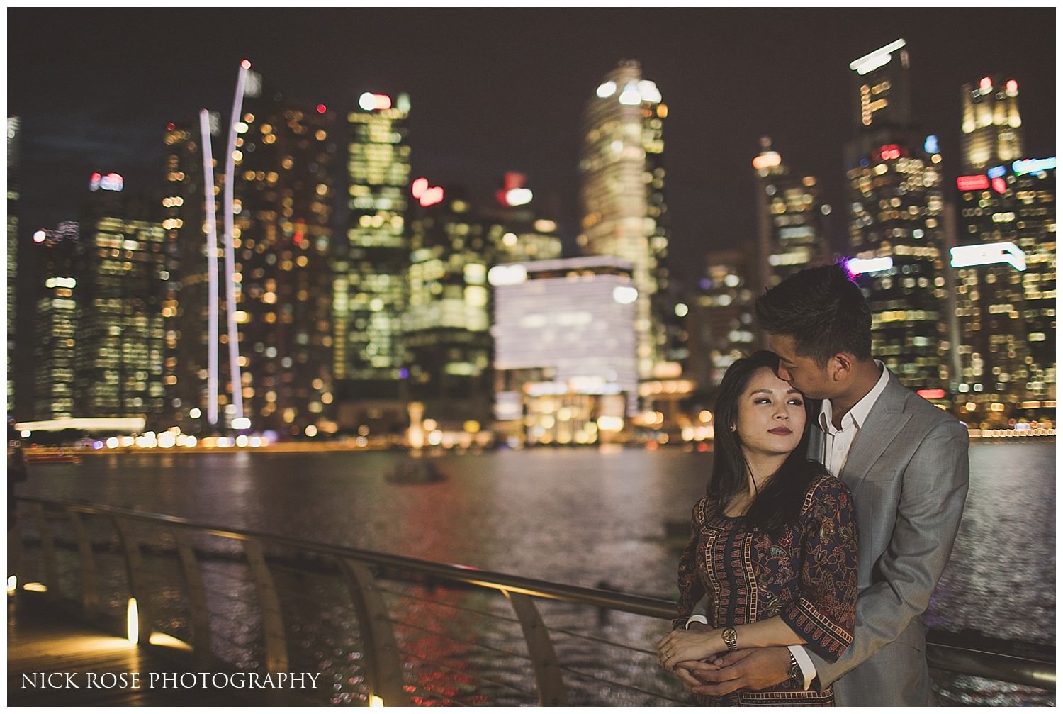  Pre wedding photograph of a couple standing in front of the skyscrapers at Marina bay in Singapore at night 