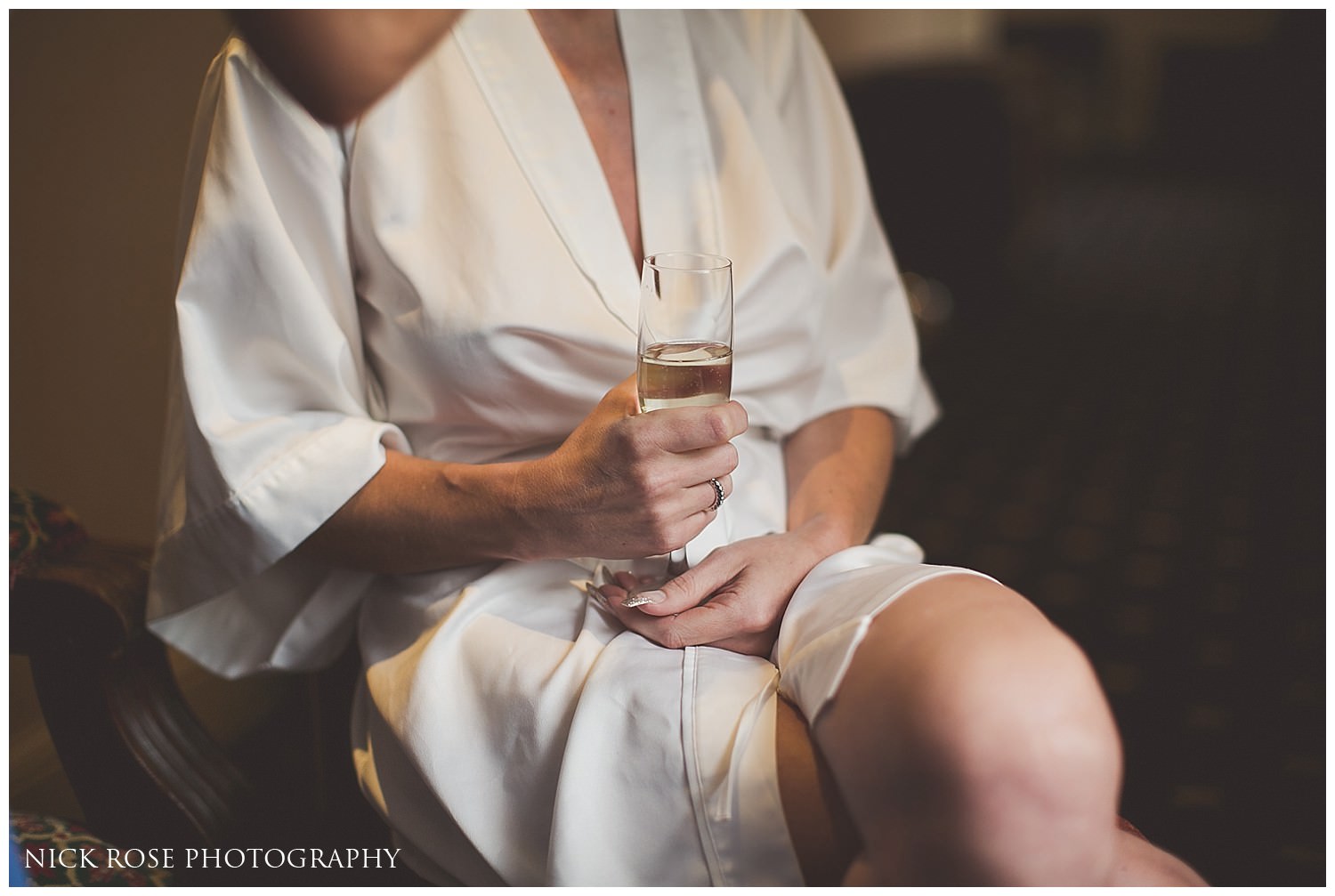  Bride sitting in a chair with a glass of champagne 