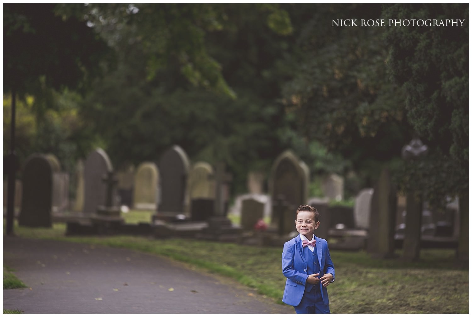  Boy in blue suit standing outside St Mary's church in Tickhill before a wedding 