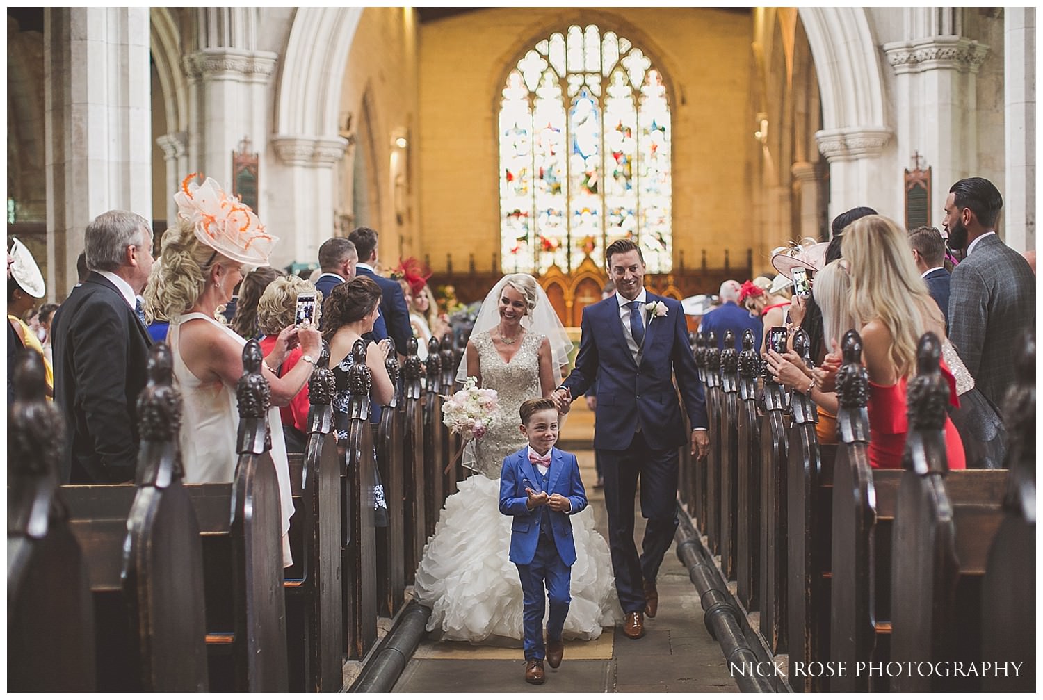  Son walking down aisle with bride and groom 