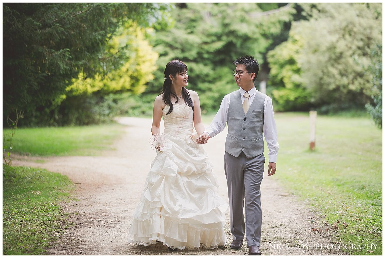  Couple holding hands under a tree in the Cotswolds countryside for a UK pre wedding photography shoot 