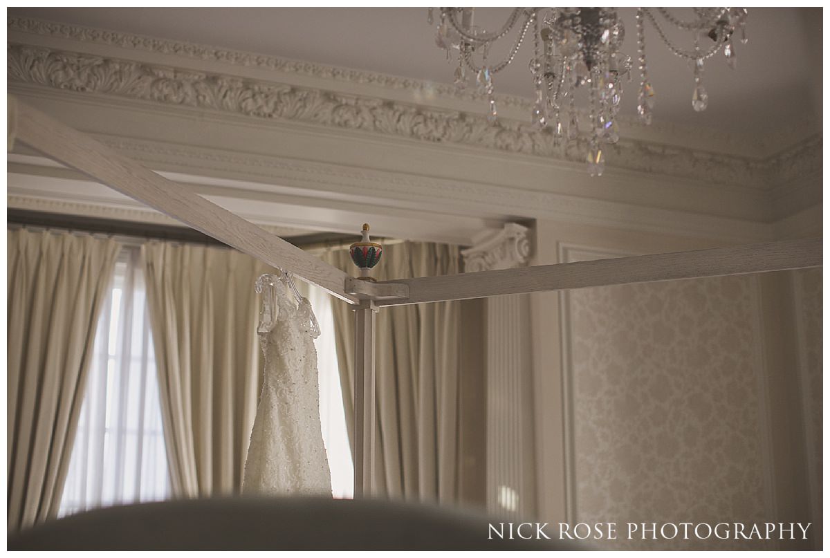  White wedding dress hanging on a four poster bed at Hedsor House in Buckinghamshire 