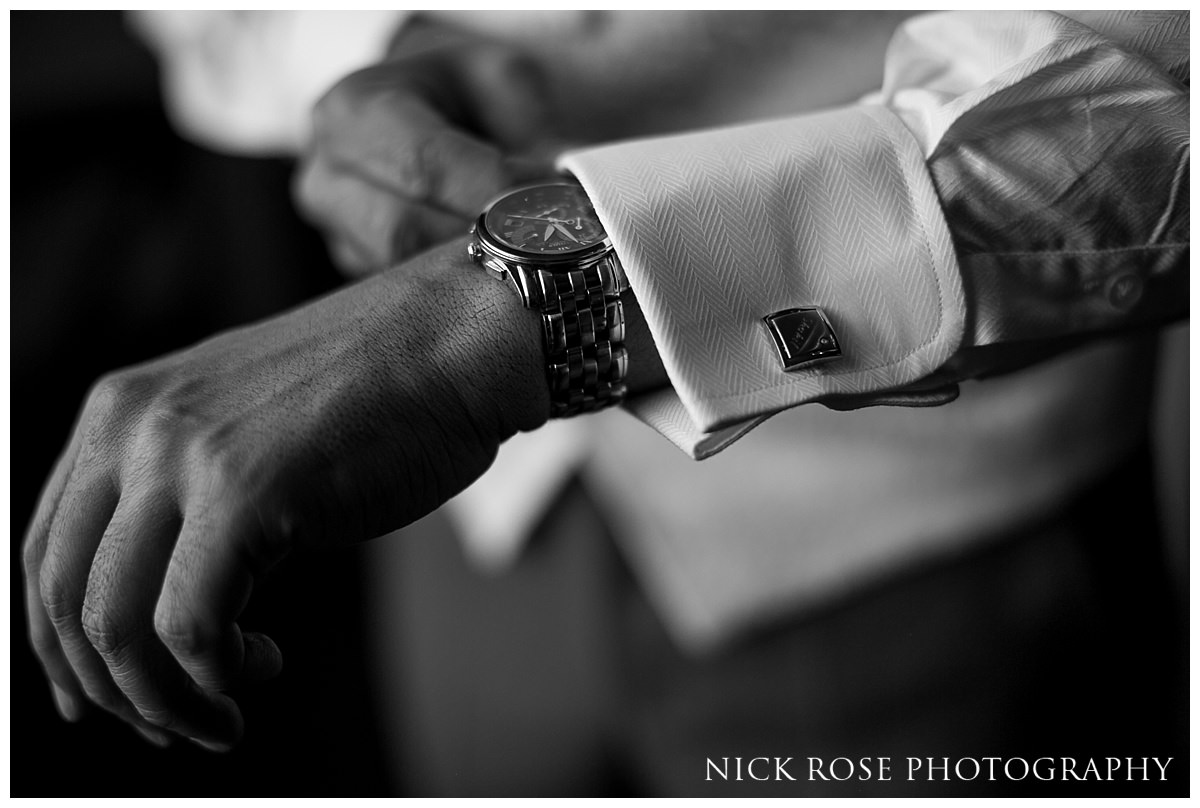  Groom putting on his cufflinks before a Hedsor House wedding 