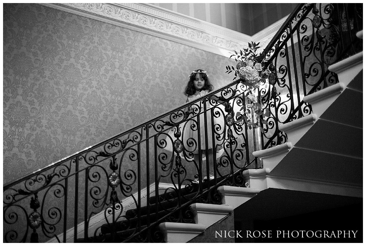  Flower girl and bridesmaid coming down stairs at Hedsor House in Bucks 