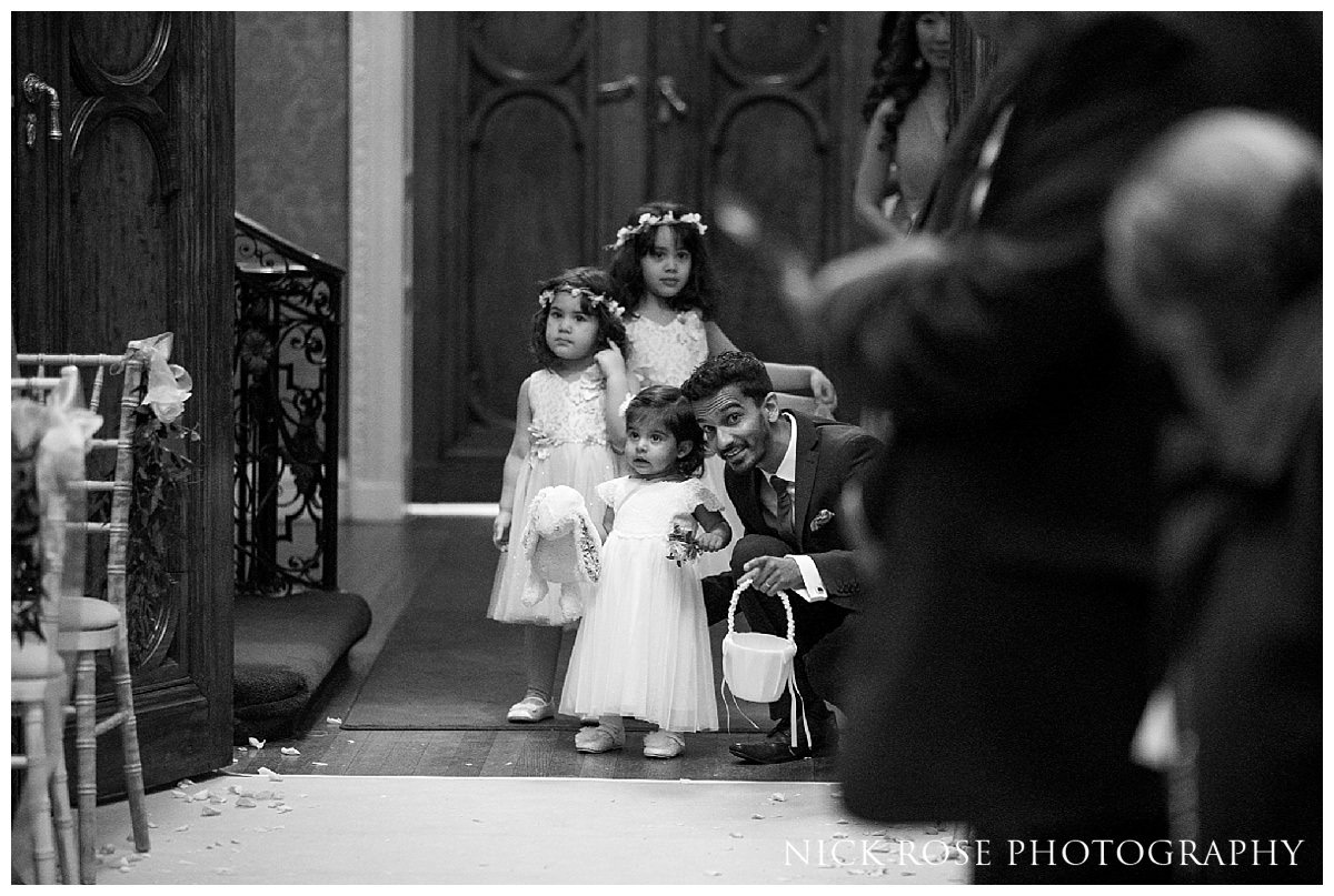  Flower girl walking up the Isle in the Centre Hall for a Hedsor House wedding in Buckinghamshire 
