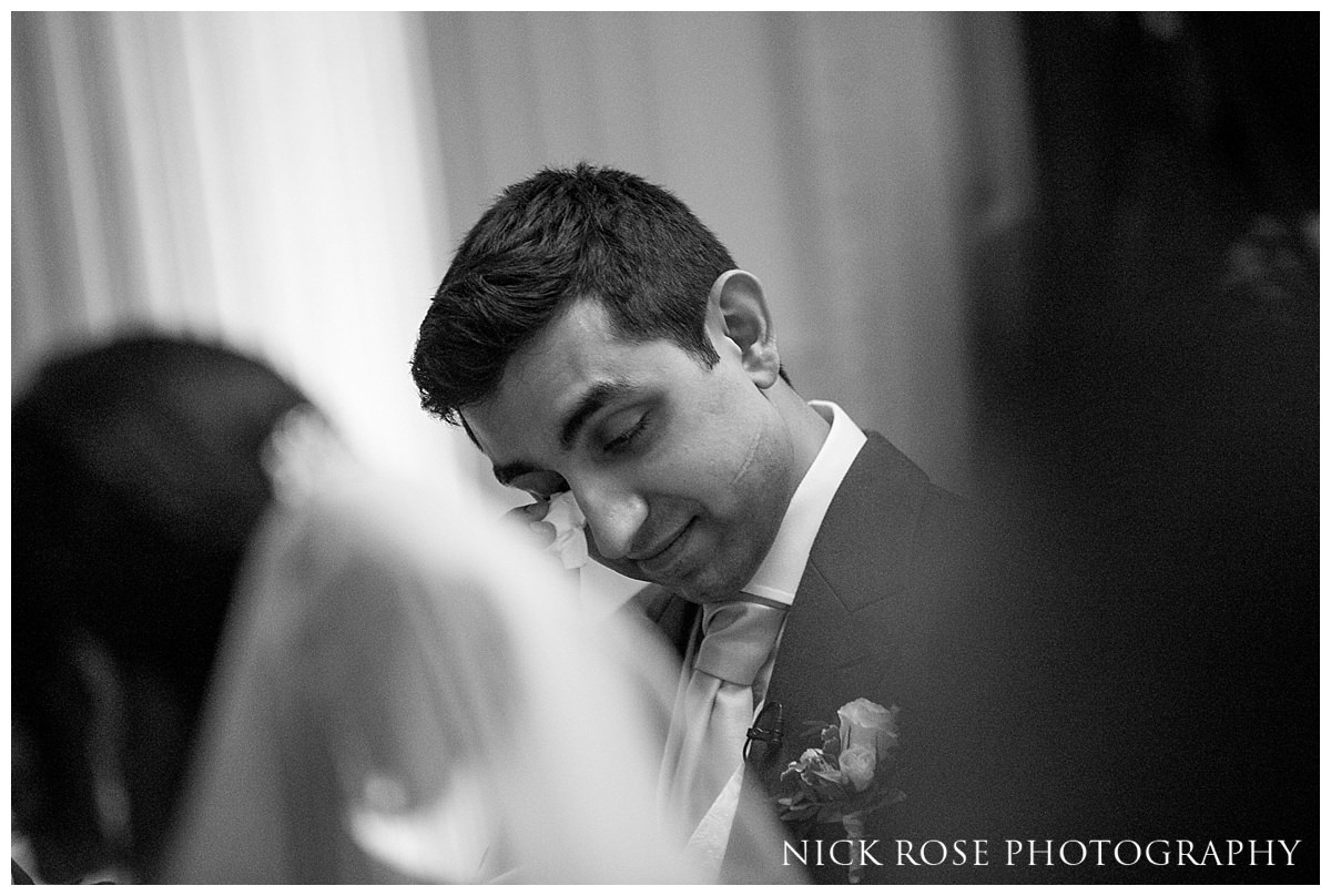  Emotional groom wipes a tear during a Hedsor House winter wedding in Buckinghamshire 