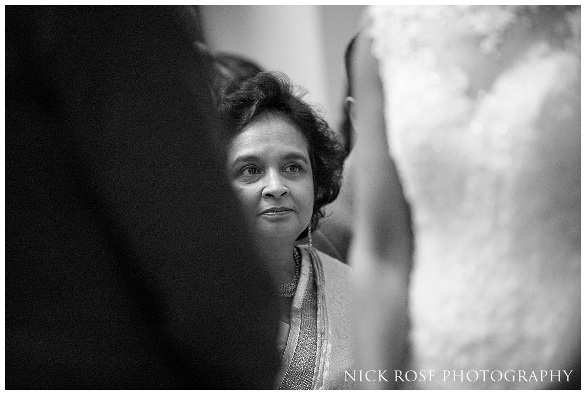  Mother of the bride looking at the couple during a wedding ceremony in the centre Hall in Buckinghamshire 