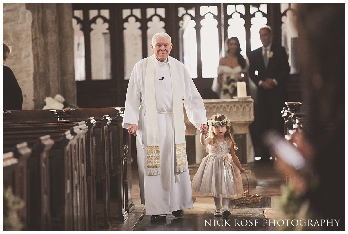  Priest and flower girl walking down the isle in St Dunstan's church Stepney, London 