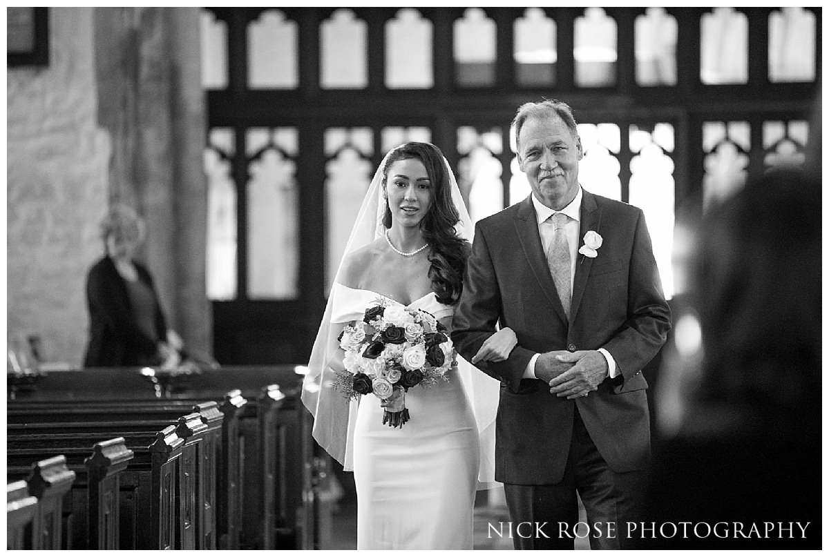  Bride and her father walking down the Isle in St Dunstan's Church in Stepney, London 
