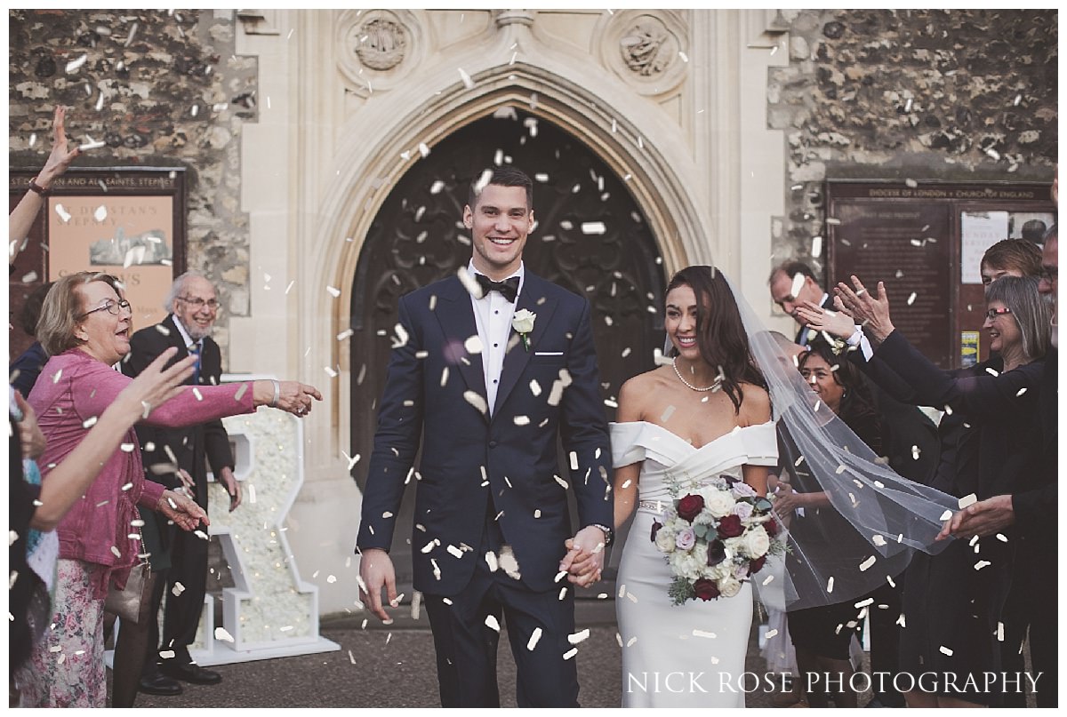  Bide and groom walking through confetti after their St Dunstan's Church wedding in London 