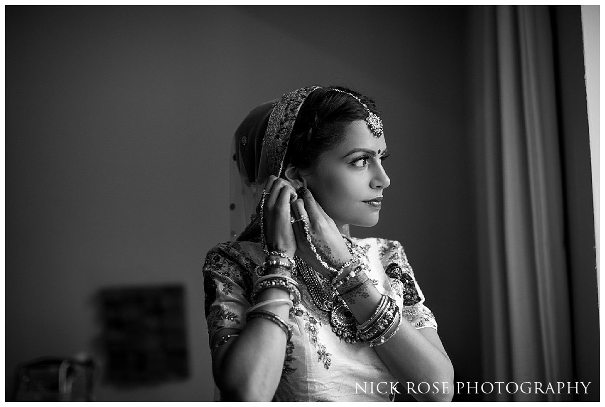  Bride standing by the window at the Grove in Hertfordshire before her hindu wedding&nbsp; 