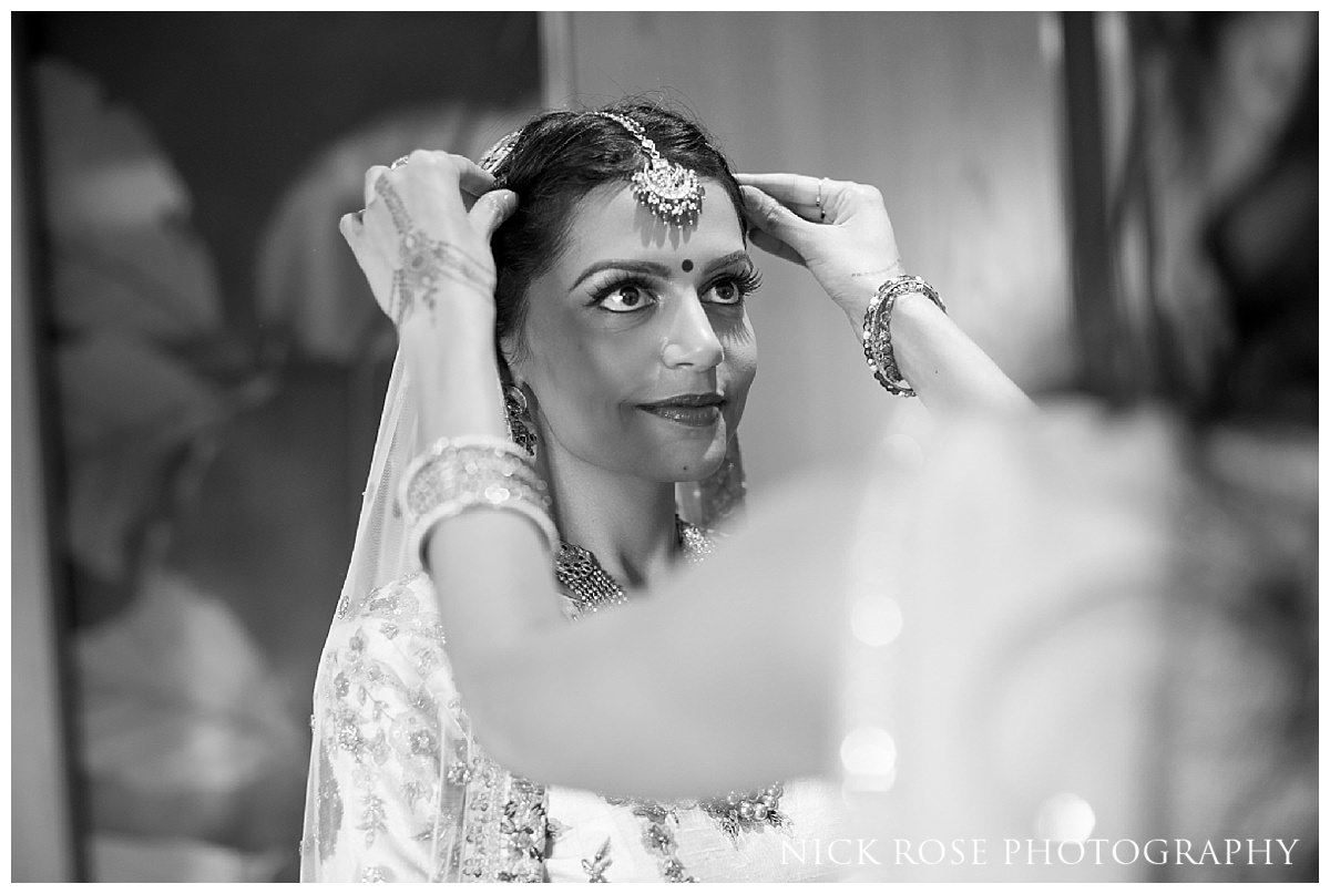 Asian bride having the final touches to her makeup put on at The Grove in Chandler's Cross 