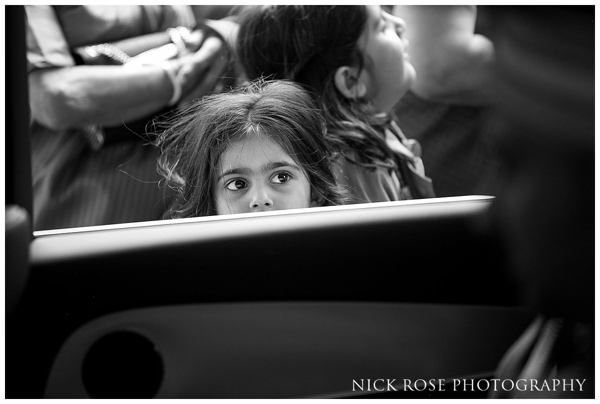  Little girl looking through a car window at the groom before his Hindu wedding 