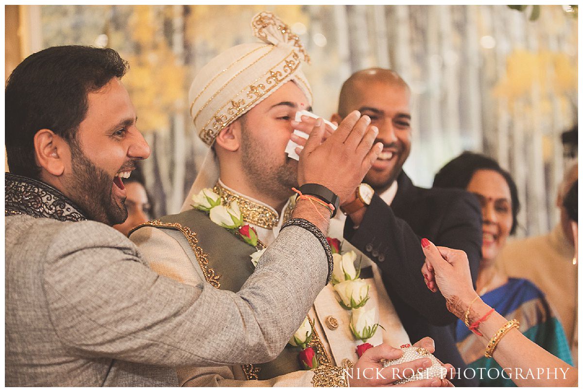  Groom having his nose rubbed by the bride's mother during a Hindu wedding ceremony in Hertforshire 